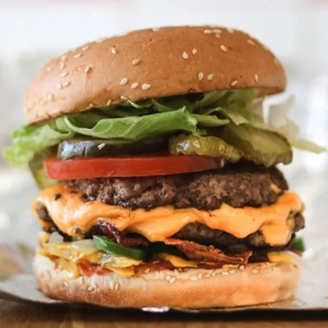A Five Guys bacon cheeseburger on its foil wrapper